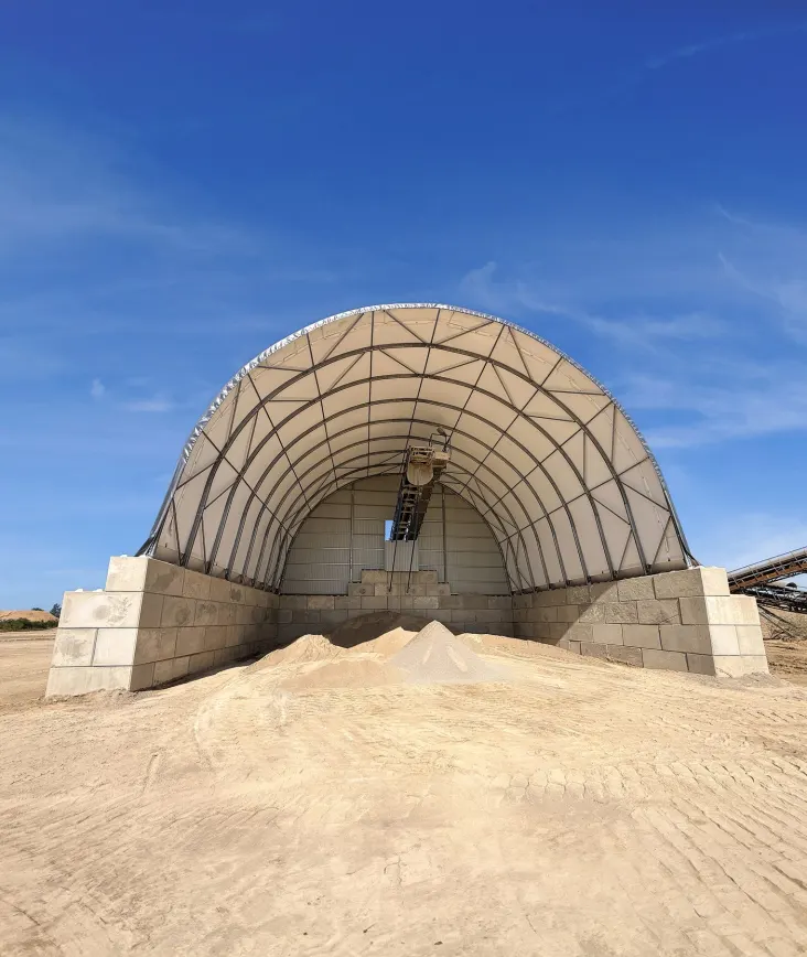 Front of the ARBENA aggregate storage hall with stockpiled material