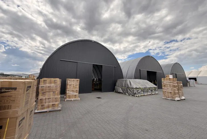 Graphite ARBENA arch buildings on a logistics yard with palletised goods